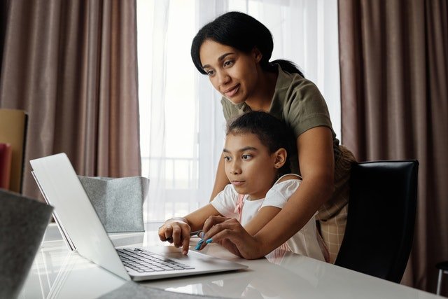 working mother helping daughter with schoolwork